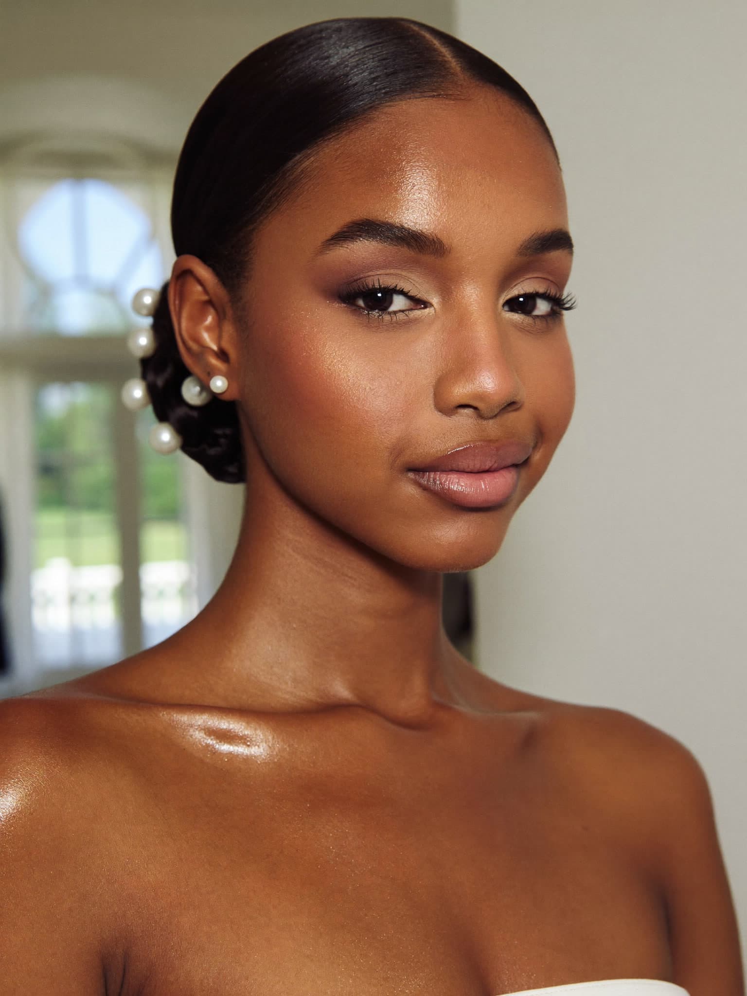 A radiant bride with glass-skin glow and a pearl-set bun — concept imagery
